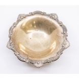 An Edwardian silver bon bon dish, cast scroll and shell border above plain body raised on