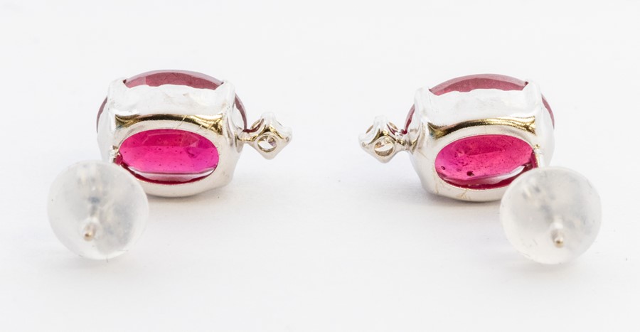 A pair of ruby and diamond 18ct white gold earrings, comprising faceted oval rubies claw set with - Image 2 of 2