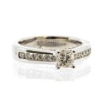 A diamond and 14ct white gold solitaire ring, the central claw set princess cut diamond weighing