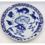 A Chinese blue and white charger decorated with prancing horses within river landscape with three