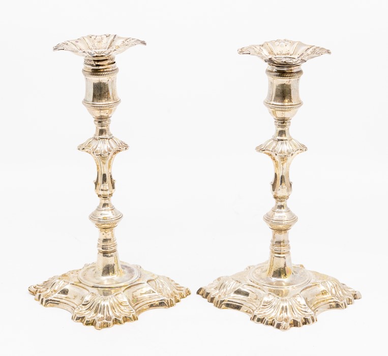 A pair of George II silver candlesticks, each on tapering knopped stems with spool shaped socket and