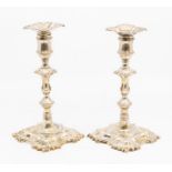 A pair of George II silver candlesticks, each on tapering knopped stems with spool shaped socket and