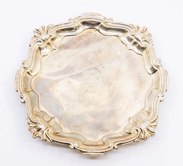 A George III silver plain salver with raised shell and wavy border, on three hoof feet, the centre