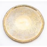 A George III silver salver, gadroon rim the centre engraved with a scrolling foliate, scale and