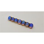 A 9ct. gold and moonstone bar brooch, set row of seven oval cabochon moonstones, length 54mm. (gross