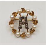 A 9ct. gold and cultured pearl wreath brooch, with stylised initial 'A' to centre set seed pearls,