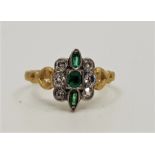 An antique precious yellow metal, emerald and diamond ring, set octagonal cut emerald to centre with