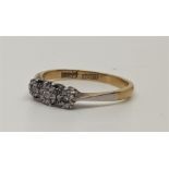 An 18ct. gold and platinum three stone diamond ring, illusion set row of three graduated round cut