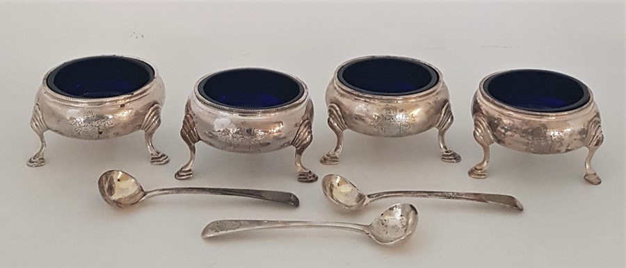 A set of four George III silver circular salts, by "I*M", assayed London 1762, with blue glass