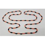 A pink coral and jet bead necklace, length approx. 118cm