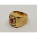 An 18ct. gold, ruby and diamond gentleman's ring, the raised cushion shape centre set mixed cut ruby