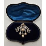 A precious white metal, diamond and natural pearl set brooch, the main mount set numerous