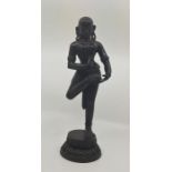 A late 19th century Indian bronze figure of an Indian goddess with raised foot, deep patina overall,