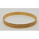 A Continental 14ct. gold bangle, with engraved and engine turned decoration, external diameter 70mm.