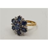 An 18ct. gold, sapphire and diamond cluster ring, with central oval cut sapphire surrounded six