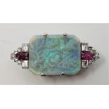 An Art Deco precious white metal, carved opal, ruby and diamond set brooch, four claw set