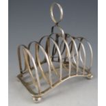 A late Victorian silver six section toast rack of unusual arched form with simple loop handle and