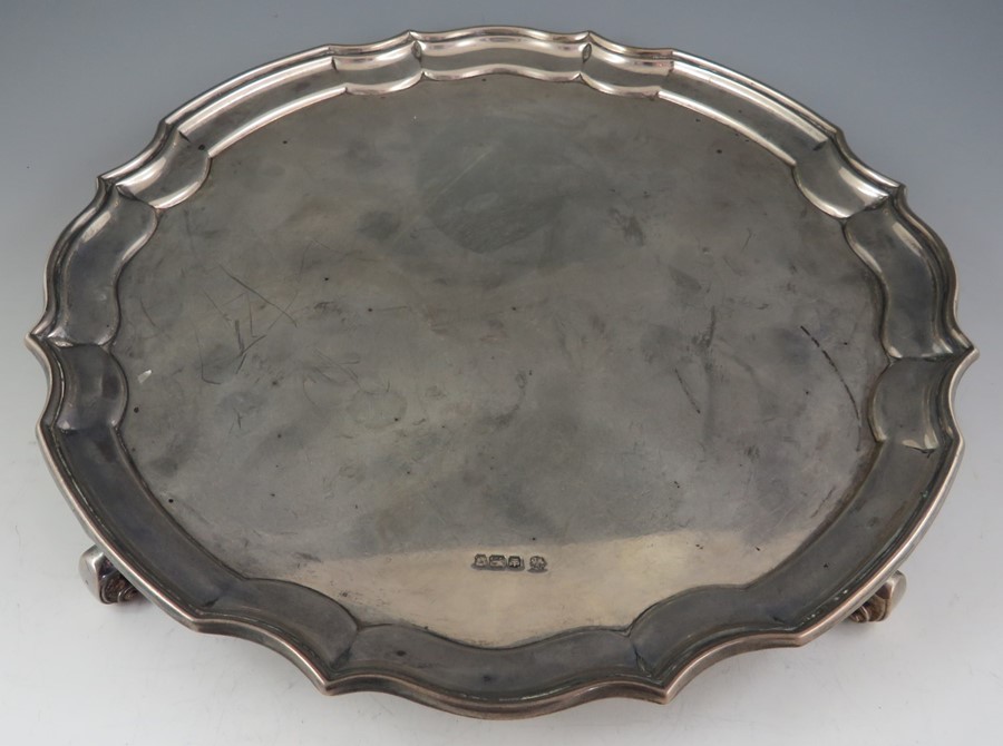 A late Victorian serpentine, circular salver with "piecrust" rim. Raised on scroll supports, 25.5 cm