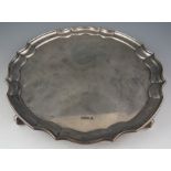 A late Victorian serpentine, circular salver with "piecrust" rim. Raised on scroll supports, 25.5 cm