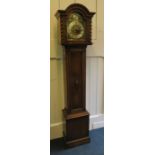 A 1920's oak carved 8 day triple train grandmother clock chiming on rod gongs.159cm high