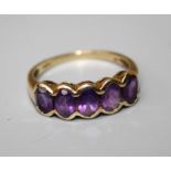 A 9ct gold ring set with five amethysts in a rub-over mount. 2 grms, Size Q.