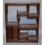 A n early 20th century Chinese rosewood carved  and pierced curio stand with two prunus decorated