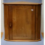 An Ercol type light elm corner cupboard.