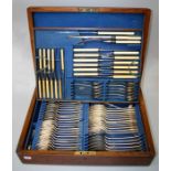 An Edwardian oak canteen of EPNS flatware, holloware  and cutlery. Monogrammed terminals