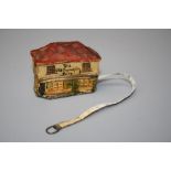 A circa 1940's tape measure, the case modelled as The Old Curiosity Shop 5 x 6 cms.