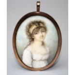 An early 19th century three quarter, oval portrait miniature on ivory of a young lady  dressed in