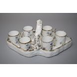 A late 19th century French porcelain liqueur set comprising lozenge shape loop handled tray and