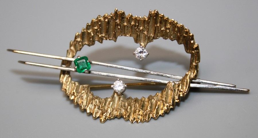 An emerald and diamond brooch, of open abstract form with a textured 9ct gold loop set with two