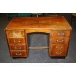 An early 20th century walnut veneer kneehole office desk. 76 x 122 x 69 cms.