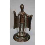 A small bronze Nuragic style bronze figure of a caped man with staff in hand. raised on a domed