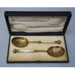 Martin Hall and co. a cased pair of gilded anointing spoons with mother of pearl handles.