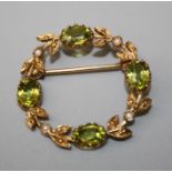 A gold peridot and seed pearl garland brooch set with four oval cut peridots and seed pearl set