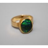 A yellow gold opal ring rub over set oval cabochon black opal