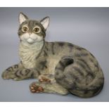 A composition model of a recumbent tabby cat with friendly expression and yellow eyes. 26 cms