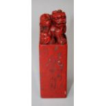 A Chinese carved red stone seal with carved kylin handle. 11cms.