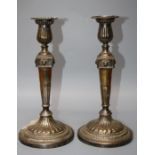 A pair of Geo IV silver circular based table candlesticks with square and lions mask mounted