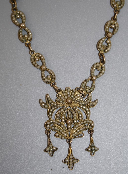 A Continental silver gilt seed pearl necklace with floral pendant drop