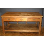 A reclaimed pine farmhouse kitchen table, the rectangular planked top over three frieze drawers,