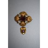 A Victorian yellow gold textured gold brooch, claw set oval cut garnet with further garnet to the