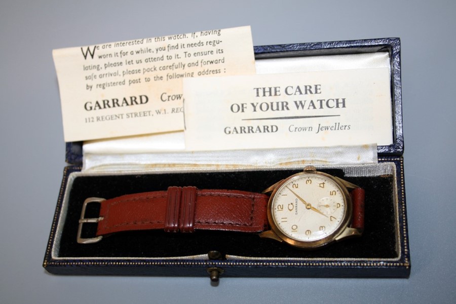 A 9ct gold Garrard gentleman's presentation wristwatch. Champagne Arabic dial with leather strap.