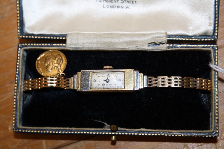 Rolex. A ladys 18ct gold wristwatch, the rectangular dial with Arabic numerals, the 18ct gold cast