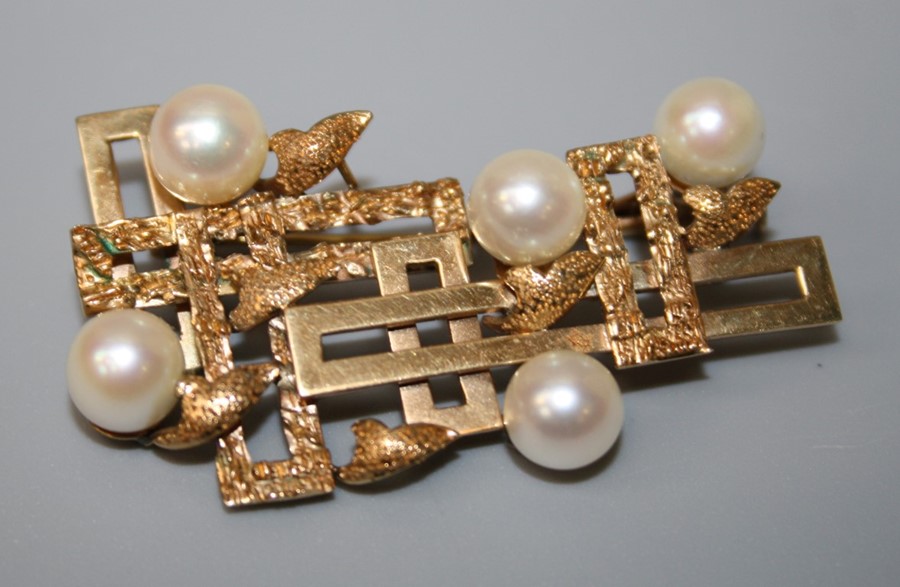 A gold and cultured pearl brooch of abstract design, polished panels and five cultured pearls.