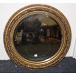 A 19th century, circular gilt gesso wall mirror with bevel plate within a beaded and tongue frame.