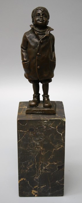 After Bergman, a cast bronze figure of a boy wearing a raincoat and boots with hands in pockets on a