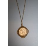 A 1912 gold sovereign in diamond shaped bark effect pendant mount to a fine trace link chain 15.5