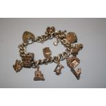 A 20th century silver charm bracelet affixed with ten charms including blacksmiths forge,fish,sewing
